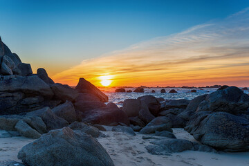 Fototapeta na wymiar Sunset over rocks on the beach at Meneham
