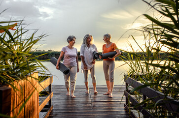 Group of senior woman with yoga mats talking after exercise.