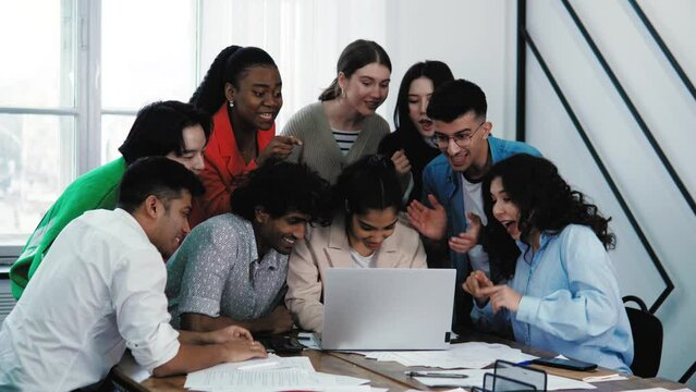 Young people students colleagues having a break playing computer games race, team support. Friends young people using laptop for playing a game at office or class. Crazy emotional diverse team workers