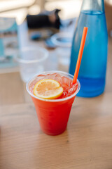 bright cocktail drink with orange slice and ice with beach vibes on table in summer
