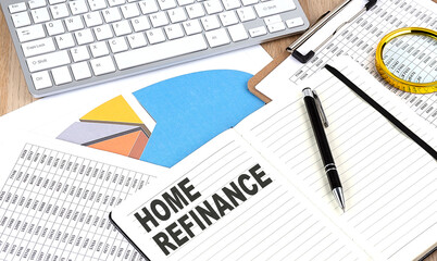 HOME REFINANCE text on notebook with chart and keyboard