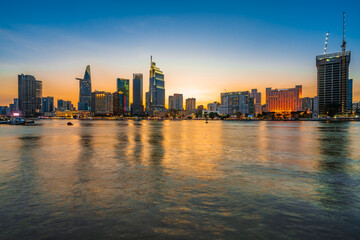 Fototapeta na wymiar Beautiful Sunset at Bitexco in Ho Chi Minh City, the famous building in Vietnam, with Vietnam flag on the top building. Colorful sky background. Travel concept