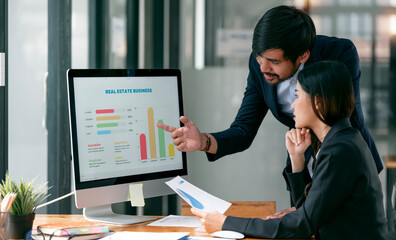Business professionals. Two of young confident business people analyzing graph data using computer while spending time in the office