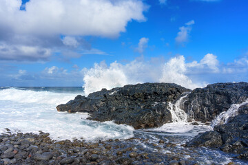 Fototapeta na wymiar Ocean Waves Crashing Against Hawaii's Rocky Shoreline