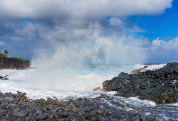 Rainbow over the rugged terrain of the Hawaiian coastline
