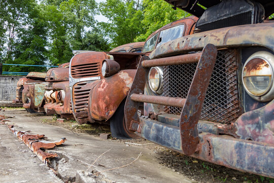 Rusted out vintage trucks left to rot on cement lot