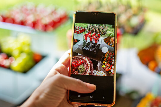 Food blogger takes photo on smartphone for social networks. Restaurant menu.