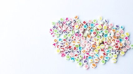 Collection of colourful beads blocks to make handmade jewellery bracelet names. heap of multi colored beads in street shop. Alphabets in kinder garden school for kids.