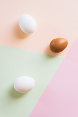 White and brown eggs on multi color background