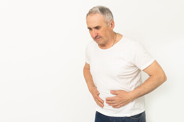 Elderly men have abdominal pain sitting on the sofa in the house. Concept Problems of the digestive...
