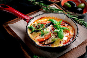 Baked eggplant with tomatoes, mozzarella cheese, basil and parmesan. Italian dish, Sicilian cuisine...