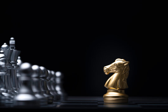 Golden knight horse chess encounter with silver chess enemy on chess board for brave heart on business competition and strategy  concept.