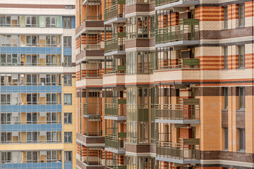 Multicolored facade of an apartment building with balconies and windows