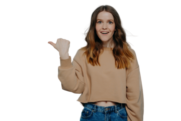 Excited young girl pointing finger somewhere posing over blue background