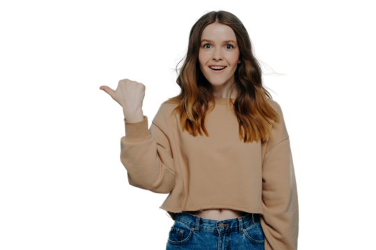 Excited young girl pointing finger somewhere posing over blue background