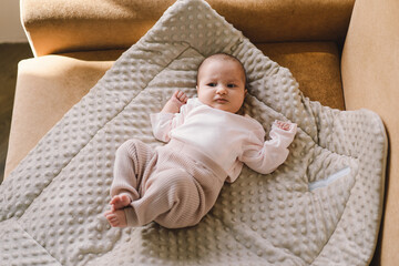 Portrait of a 1 month old baby. Cute newborn baby lying on a developing rug. Love baby. Newborn baby and mother.