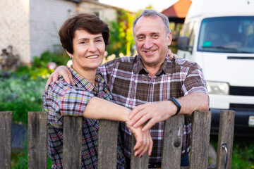 Naklejka premium family of retired farmers together near fence of their homestead