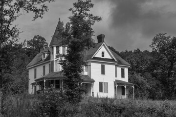 Boarded up and abandoned victorian mansion in the woods