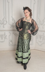 Beautiful young smiling woman wearing green medieval vintage Victorian Style dress