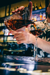 man hand bartender making cocktail in glass on the bar counter
