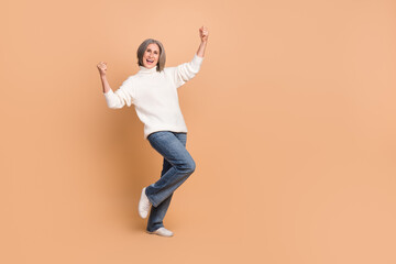 Fototapeta na wymiar Full length photo of overjoyed business woman mature aged gray hair stylish outfit fists up good profitable sales isolated on beige color background