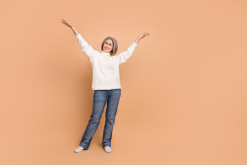 Full body size photo of attractive pretty cheerful woman wear white sweater raise arms up celebrate good mood day isolated on beige color background