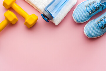 Sport fitness background with sneakers and dumbbells, top view