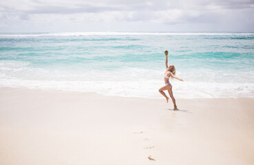 Fototapeta na wymiar Relaxed woman with coconut on seashore