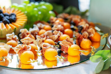 Delicious appetizers with prosciutto and peach at party. Close up. Catering event