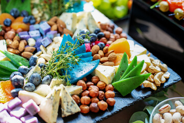 Cheese plate served with dried apricots, berry and nuts. Flat lay. Food concept