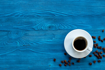 White cup of hot black espresso with coffee beans