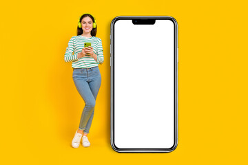 Full size photo of cute casual wear charming girl chatting phone promote ad isolated on yellow color background