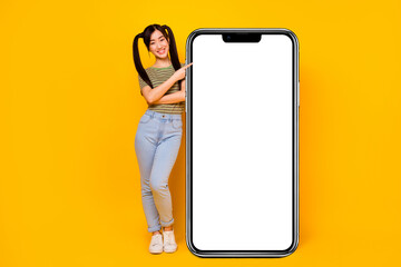 Fototapeta na wymiar Full size photo of charming girl show huge phone display recommend new shopping application isolated on yellow color background