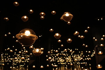 blur bokeh circus tube lamp hang from ceiling in dark room like firefly 