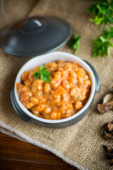 beans stewed with vegetables and spices, in a bowl .