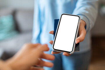 Unrecognizable Woman Giving Passport And Blank Smartphone To Female Hand