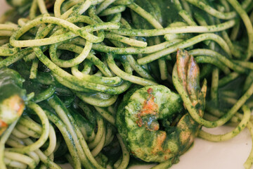 Delicious homemade Italian seafood pasta with shrimps, basil pesto and fresh spinach