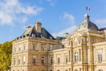 French flag waving on the Luxembourg Palace in the Jardin du Luxembourg garden in Paris France, home of the French Senate - obrazy, fototapety, plakaty