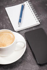 Smartphone, coffee with milk and notepad for notes. Work or relaxation with mobile phone