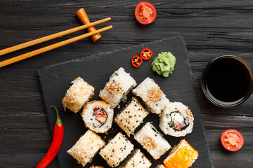 close up of sushi rolls on black tray