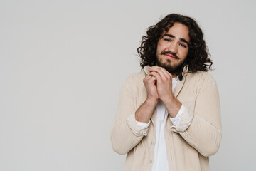 Smiling attractive hispanic man gesturing while posing isolated over white background
