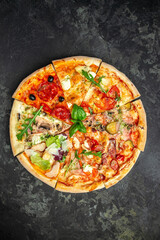 slices of pizza with different toppings on a dark background, vertical image. top view. place for text