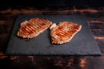 Grilled minute steak of marbled beef on a stone slate board