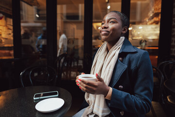 Stylish young african woman at cafe having coffee