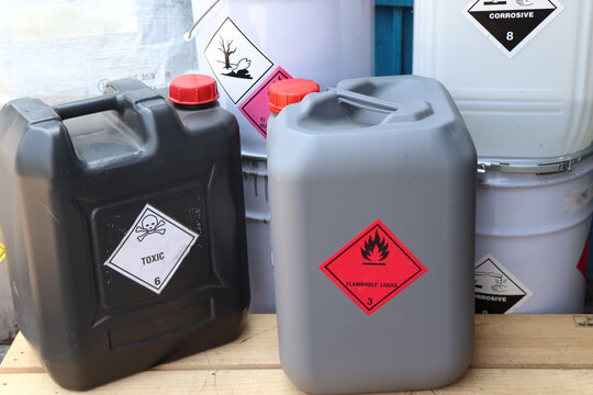Corrosive chemical symbols on a black chemical tank
