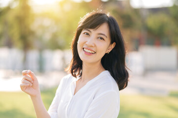 Portrait young beautiful asian woman with happy smile around outdoor park in sunny summer day