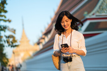 Portrait beautiful young asian woman with smart mobile phone around outdoor street view in a summer day