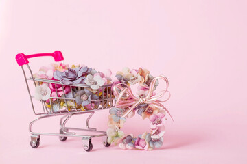 International Women's Day. Banner, flyer, beautiful postcard for March 8. Flowers in the shape of the number eight and a grocery cart on a pink background. Buying a flower by March 8.