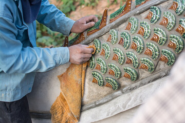 man  gluing ceramic tile on  Naga stair in temple, construction Naga stair in Thailand