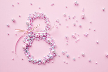 International Women's Day. Banner, flyer, beautiful postcard for March 8. Pearls in the shape of the number eight on a pink background.